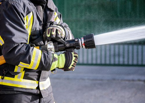 brandweerman gebruikt blusspuit